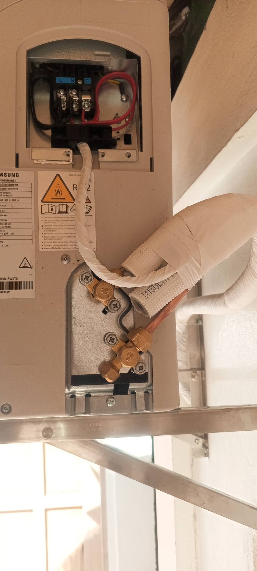 Outdoor aircon unit with insulated refrigerant lines and electrical connections